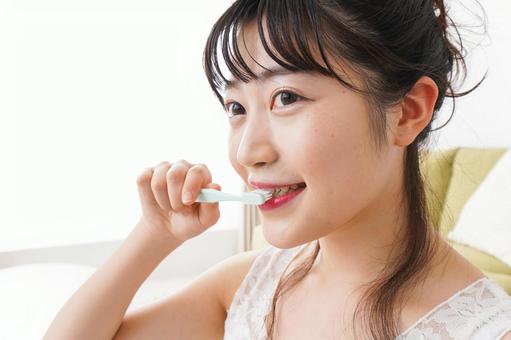 女性がホワイトニングで歯を磨いている